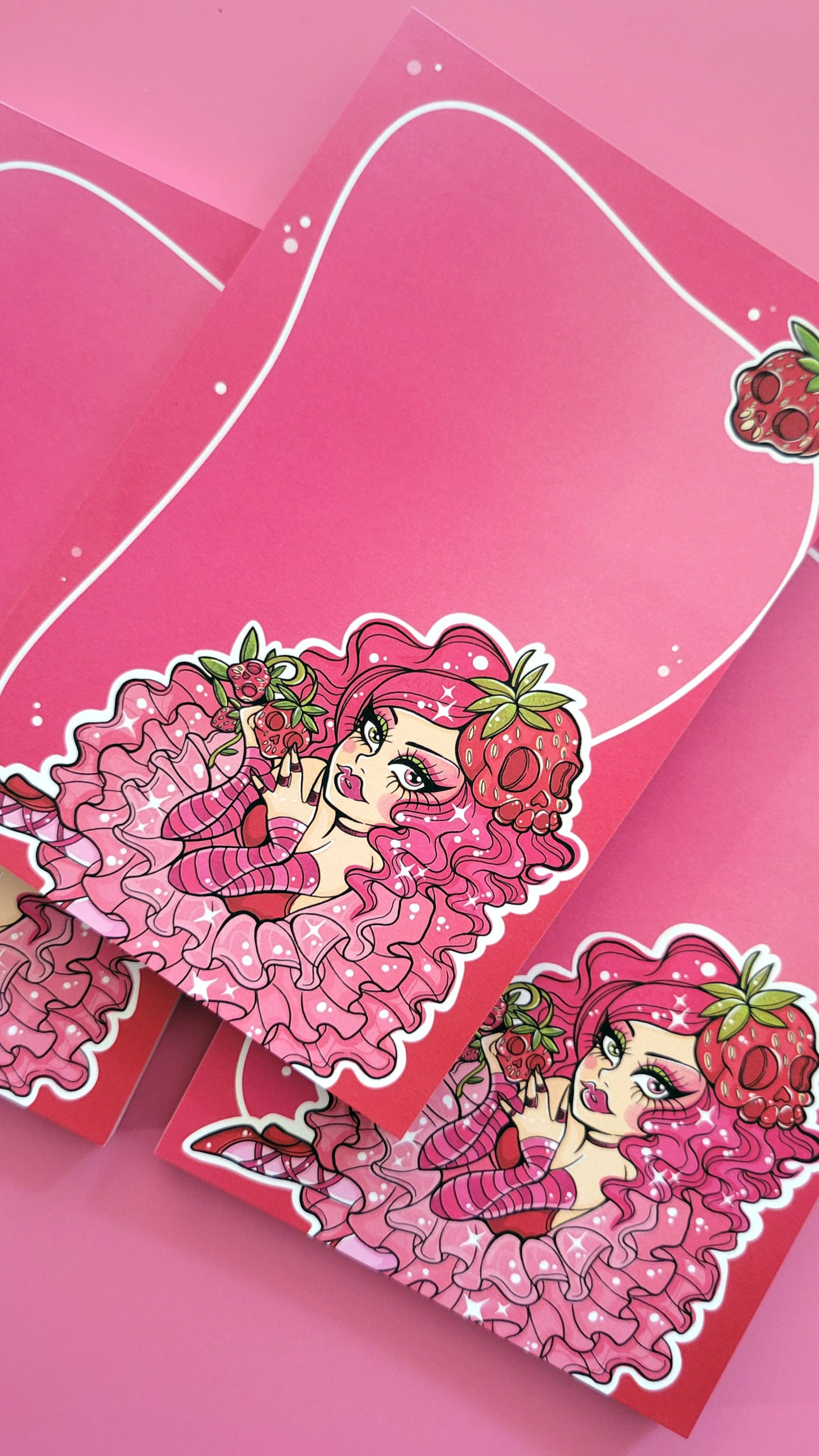 Pink pastel kawaii goth girl spooklette character holding skulls and strawberry on a pink background